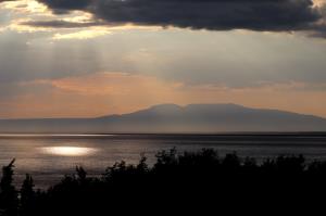 Sunlight peaking through clouds with Mount Susitna in background