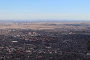 View of Boulder at summit of Mt. Sanitas with Denver in distance