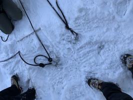 Looking down at knots tied to anchors at top of ice climbing route on second day