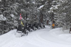 Snowmobiles parked along part of trail