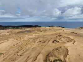 View of sand dunes with ocean from drone