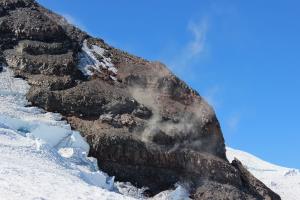 Dust clouds on Disappointment Cleaver from guides clearing path of rock fall hazards