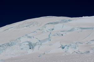 View looking up at Mt. Rainier while descending with climbers near the right