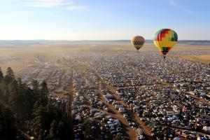 Hot air balloons hovering over camping area