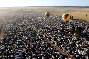Hot air balloons over festival camping area