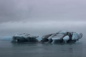 Iceberg seen from land with fog