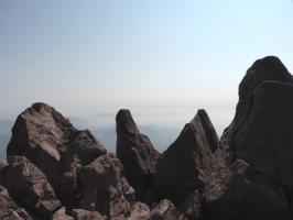 Tall rocks and smoke from forest fires seen from Lassen Peak summit
