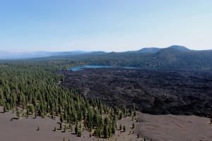 View of Butte Lake and Fantastic Lava Beds from Cinder Cone with smoke from forest fires in distance