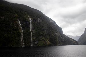 Multiple waterfalls with clouds seen in Doubtful Sound