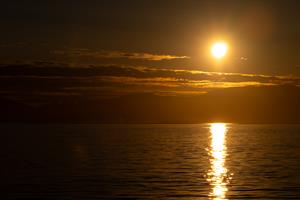 Sun near midnight seen from boat outside Tromsø